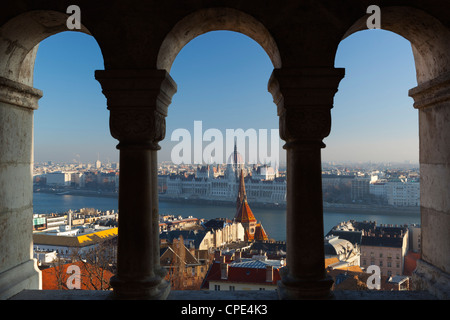 Parliament (Orszaghaz) and River Danube through arches of Fishermen's Bastion (Halaszbastya), Buda, Budapest, Hungary, Europe Stock Photo