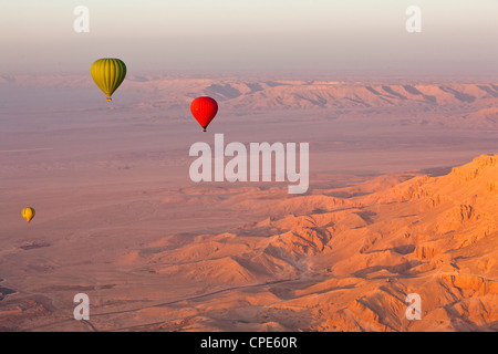 Hot air balloons suspended over the Theban hills of Luxor and the Valley of the Queens at sunrise, Thebes, Egypt, Africa Stock Photo