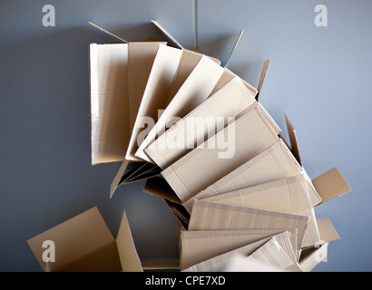 carton open boxes stacked on curved circle shape on gray wall Stock Photo