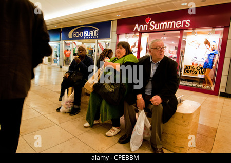 people sitting looking depressed in shopping centre Stock Photo