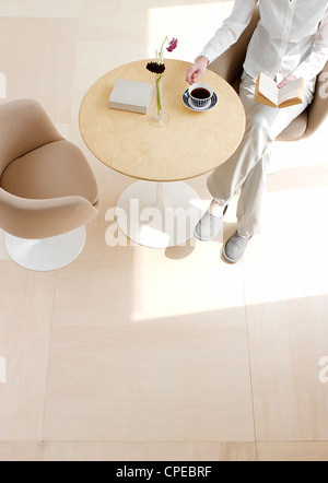 Women Drinking Tea And Reading Book, Overhead View Stock Photo