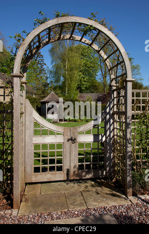 Garden feature Arch with gates leading into lawn area and feature gazebo Stock Photo