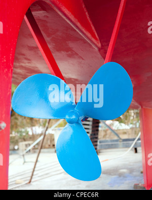 blue sailboat propeller in a red painted hull Stock Photo