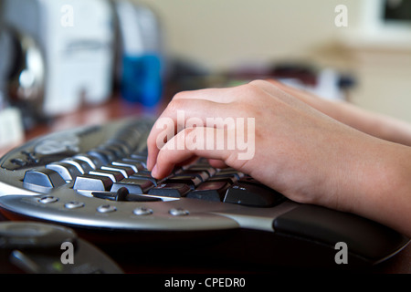 Girl typing on ergonomic wireless keyboard Stock Photo