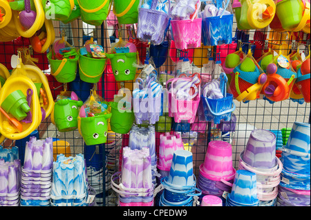 Colourful beach sandcastle buckets and spades for sale in a Devon town Stock Photo