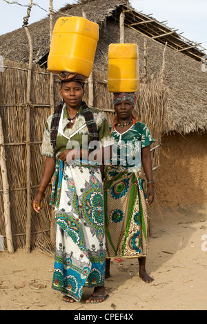 Women carrying water on their heads in Guludo village in the Quirimbas National Park in northern Mozambique. Stock Photo