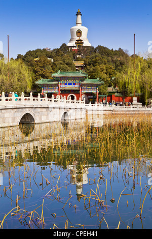 The White Pagoda in Beihai Park, Beijing, China, reflected in the lake on a sunny day in early spring. Stock Photo