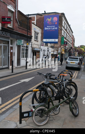 Advertisement for "Banglatown Curry Capital 2012" in Hanbury St, off Brick Lane, London covering street art by the artist Roa. Stock Photo