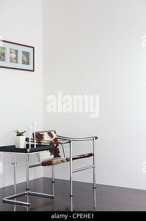 Potted Plant On Side Table Near Chair Stock Photo