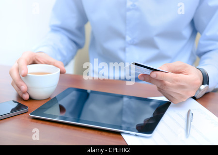 Businessman using a credit card and digital tablet for buying on-line. Stock Photo