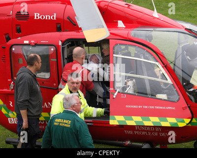 Medic handing baby to mother in helicopter of Devon air ambulance, UK Stock Photo