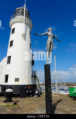Scarborough, Yorkshire, UK - the Diving Belle sculpture next to the harbour lighthouse. Stock Photo