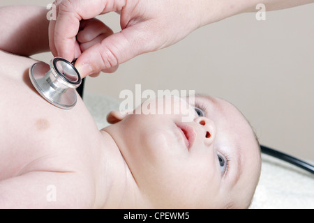 Stethoscope listening to a baby's heart beat Stock Photo