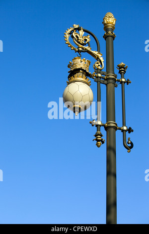 Ornate street lamp isolated on a blue sky, located in front of the Royal Palace in Madrid, Spain. Stock Photo