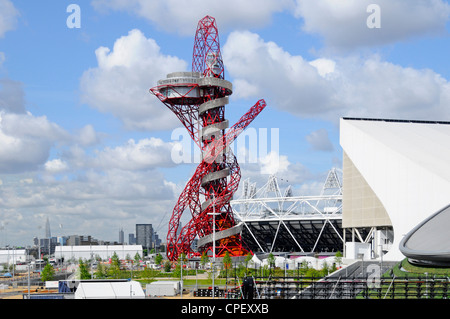 Part of stadium & ArcelorMittal Orbit tower Aquatics centre in the 2012 London Olympic park with Shard and City of London skyline distant Stratford UK Stock Photo