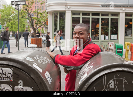 A young man listens to music while waiting outside in New York City. Stock Photo