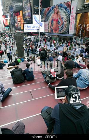 People hang out and enjoy the atmosphere of Times Square in New York City. Stock Photo