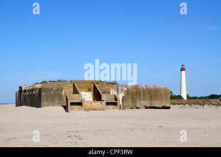 World War II artillery bunker on the beach in Cape May, New Jersey, USA. The Cape May Lighthouse can be seen to the right. Stock Photo