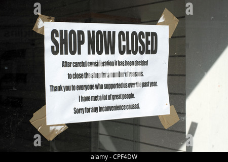 Shop closing down notice in shop window Stock Photo