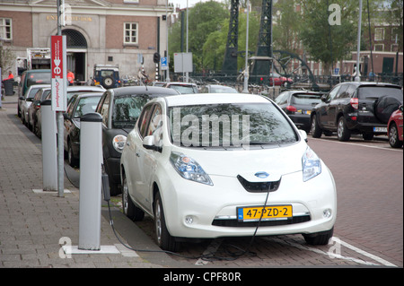 Nissan Leaf electrical car being charged at charging station Stock Photo