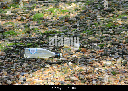 Empty wine bottle left on beach. Stock Photo