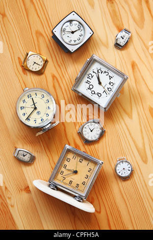 The old alarm clocks, watches lying on a wooden surface Stock Photo