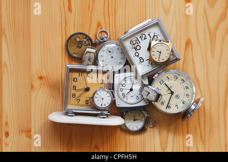 The old alarm clocks, watches, stop watch lying on a wooden surface Stock Photo