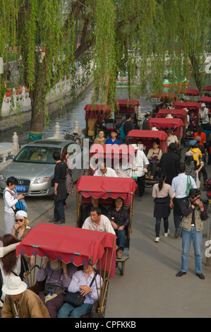 Rickshaw drivers take tourists for Hutong tour at Hou Hai Lake, Beijing, China Stock Photo