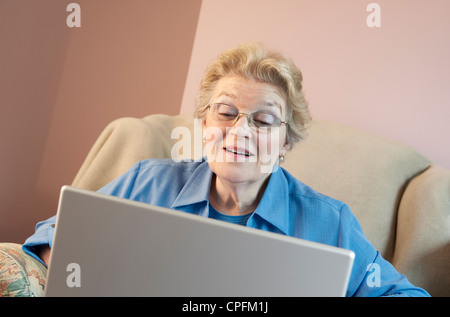 Mature woman using laptop and smiling Stock Photo