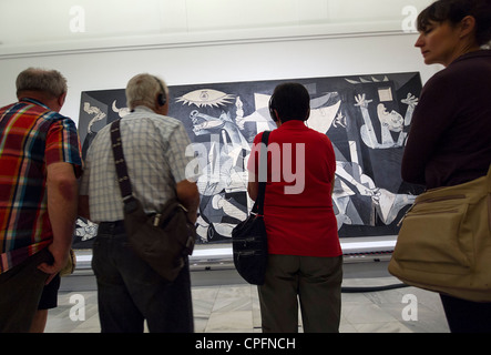 Visitors admiring the 'Guernica' painting by Pablo Picasso at the Reina Sofia modern art museum in Madrid, Spain Stock Photo