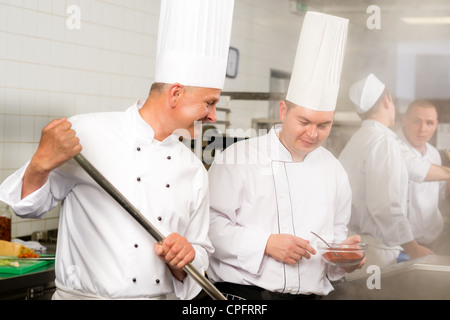 Two male cooks working in professional industrial kitchen prepare food Stock Photo