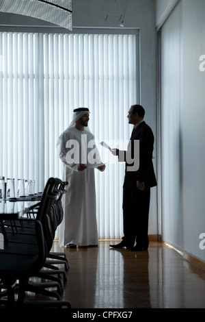 Two businessmen with documents having a meeting in a conference room. Stock Photo