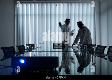Two arab businessmen having a meeting in a conference room, man pointing at the presentation. Stock Photo