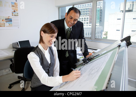 Two architects working on blueprint in office. Stock Photo