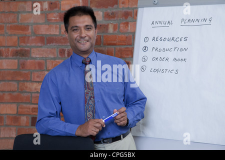 Portrait of businessman giving presentation, smiling. Stock Photo