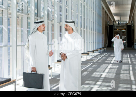 Arab businessmen talking in office hallway. Stock Photo