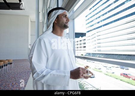 Arab businessman with teacup, standing by the window. Stock Photo