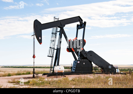 Pump jack starting the lifting stroke to brink crude oil up out of a producing oil well. Stock Photo