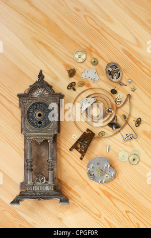 Clock parts lie on a wooden surface Stock Photo