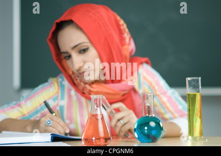 Teacher writing with focus on measuring tubes Stock Photo