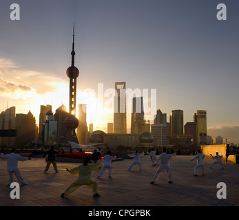 Tai Chi group exercising facing the sunrise and the Pudong high rise towers from The Bund Shanghai China Stock Photo