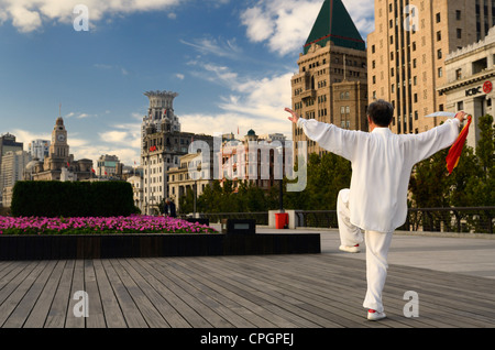 Man in white with Tai Chi sword exercising on the Bund at dawn in Shanghai China Stock Photo