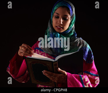 Young woman reading Koran Stock Photo
