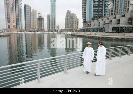 Friends conversing with sea and buildings in background Stock Photo