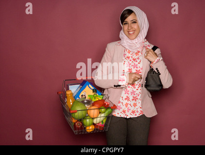 Young woman with shoulder bag and shopping cart, portrait Stock Photo