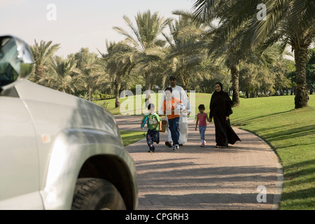 Parents and children walking at park on pavement Stock Photo