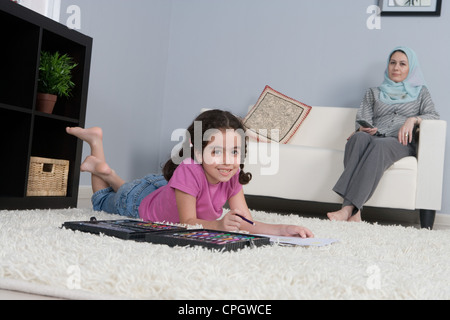 Arab mother with daughter doing homework in the living room Stock Photo
