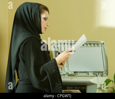 Young businesswoman using photocopier Stock Photo