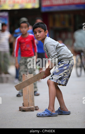 Nepali boys playing cricket in the street of Thamel Nepal Stock Photo