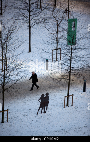 A man walking through snow on his way to  his workplace  in Spinningfileds  Hardman Boulevard Manchester city centre Stock Photo
